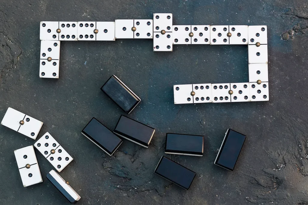Un set clásico de fichas de dominó colocadas en disposición de juego sobre una mesa
